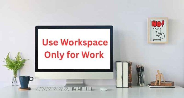 A tidy desk setup with a desktop monitor displaying the message “Use Workspace Only for Work” in red text, promoting a productivity technique “Use Workspace Only for Work”. The workspace features books, a keyboard, a coffee cup, and minimal decorations, which reinforce focus and organization.