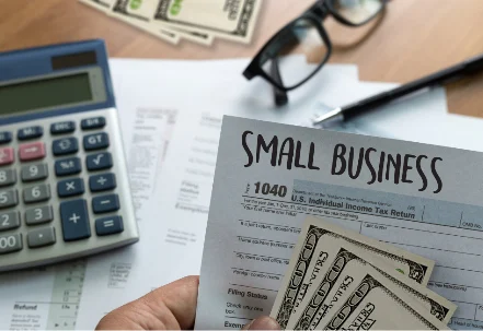 Small business income tax return documents on a table with calculator and glasses